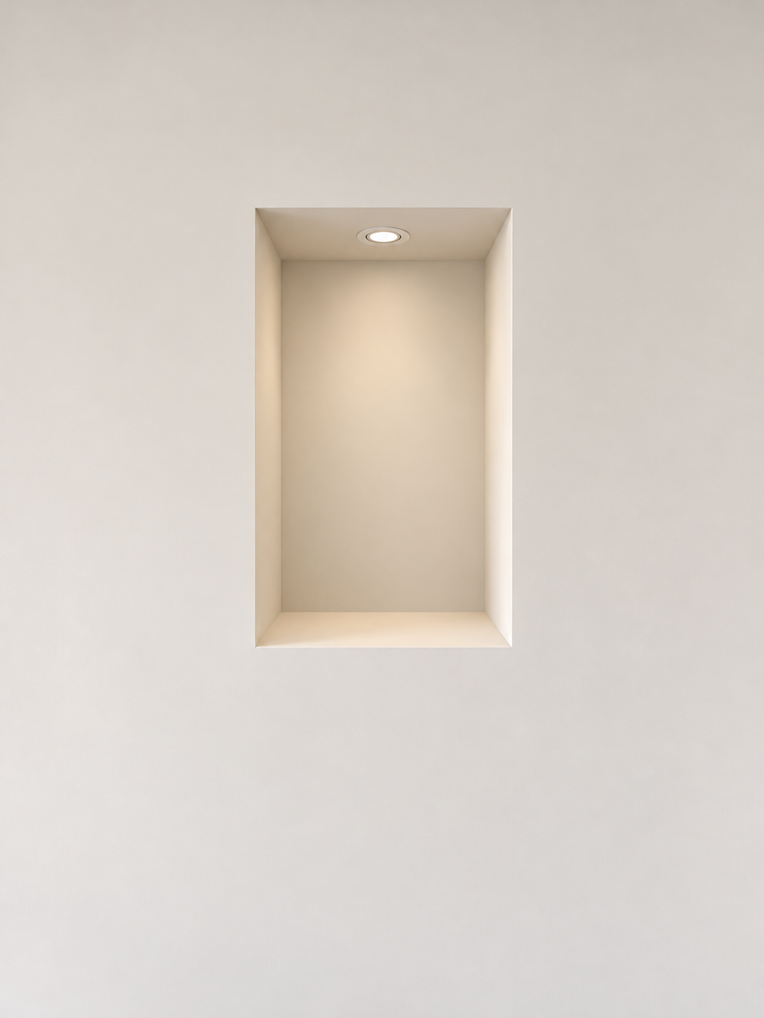 Niche verticale dans un mur clair, éclairée par un spot encastré dans sa partie supérieure.