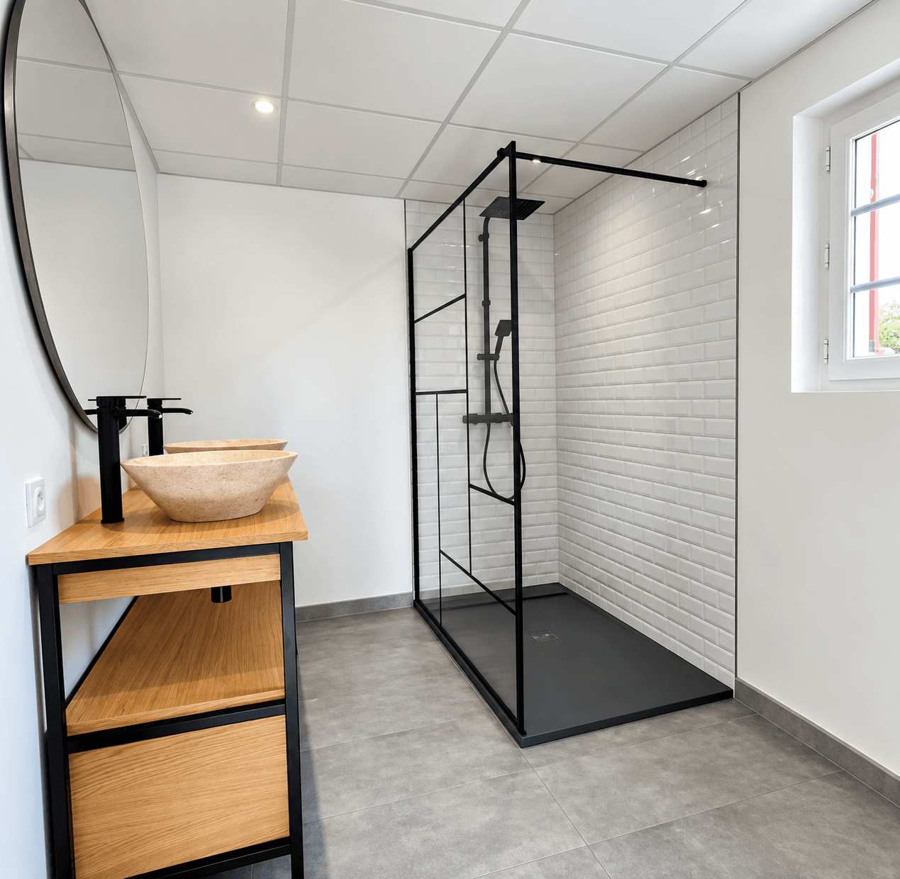 Salle de bains terminée avec meuble en bois, double vasque et douche noire