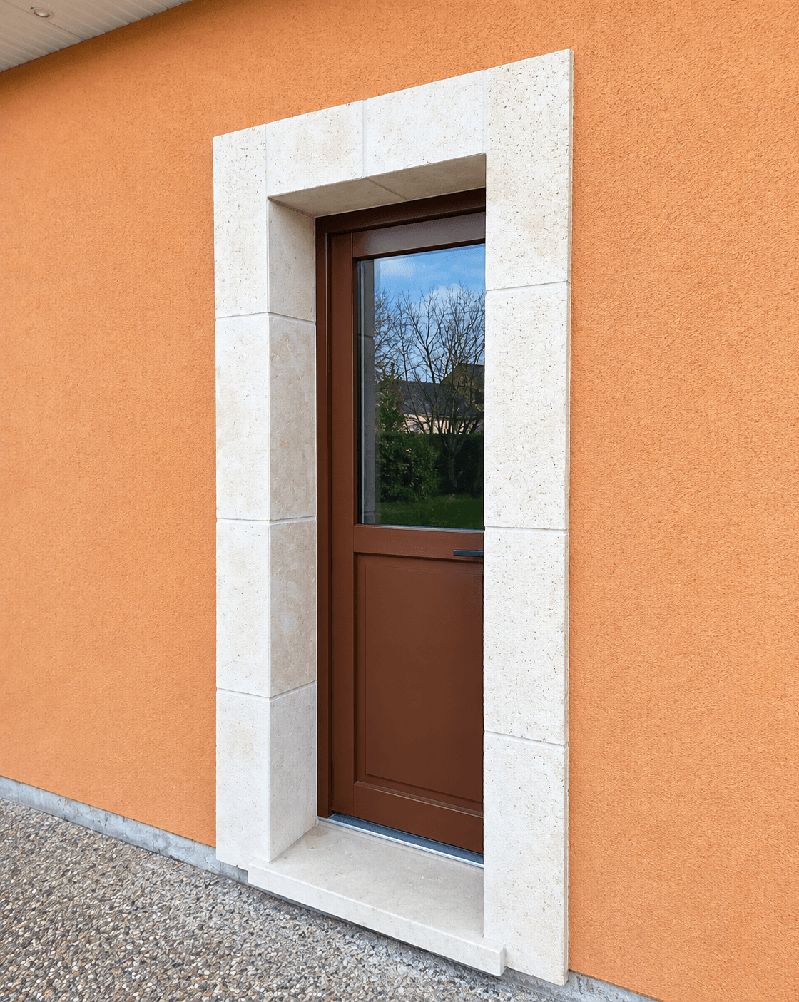 Nouvelle porte d'entrée vue de trois quarts avec encadrement en parement de pierre